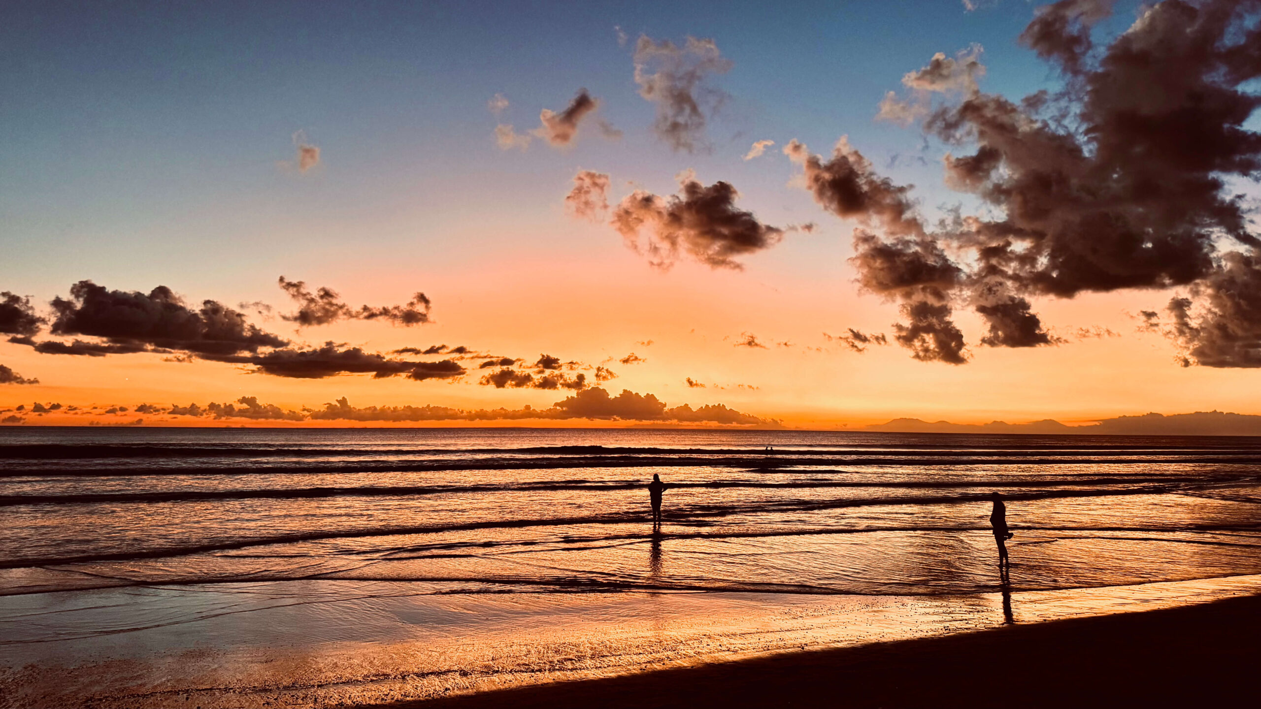 Kleine kinderen (baby en peuter) genieten van zonsondergang op Seminyak Beach, Bali