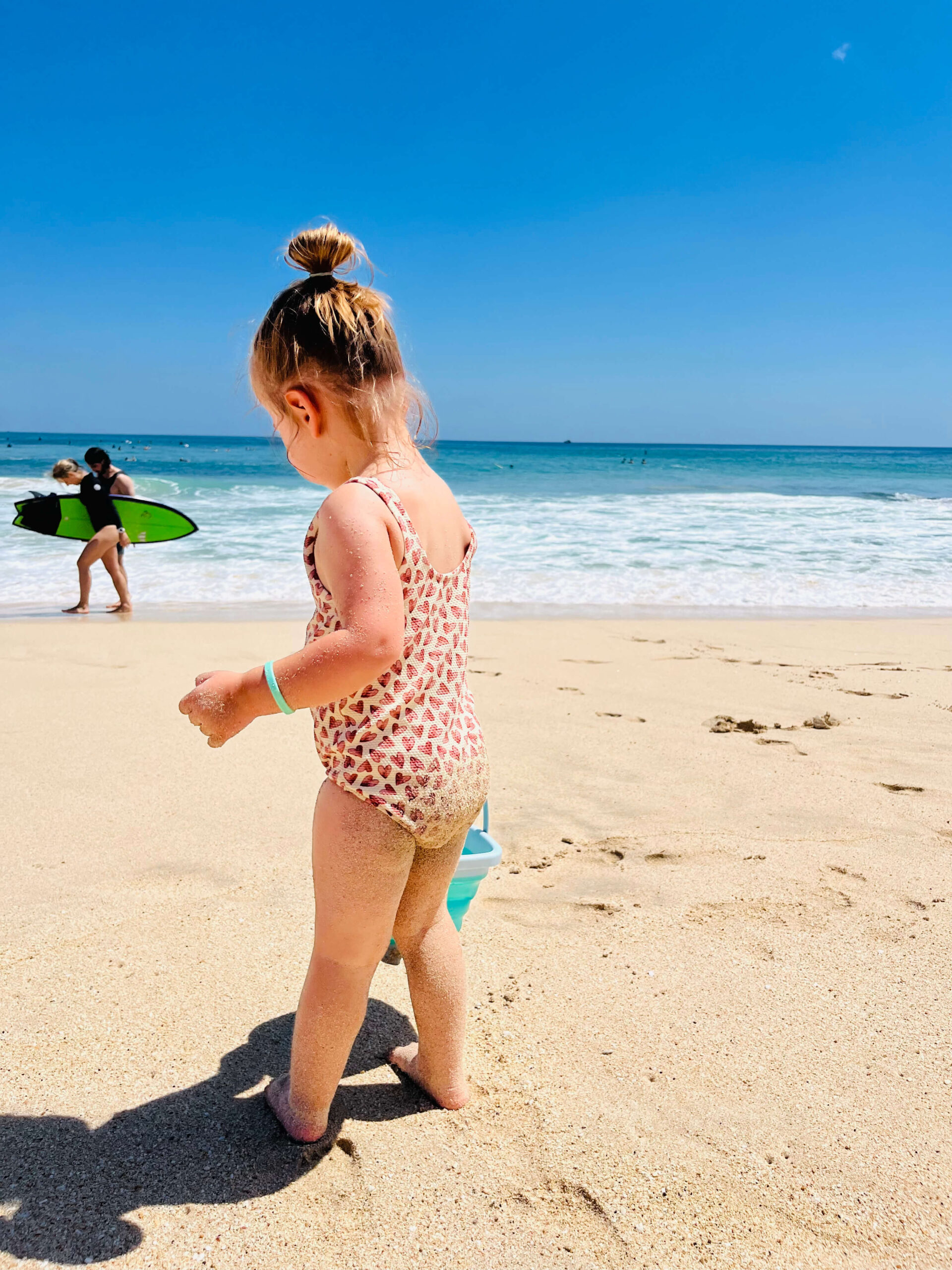 Toddler watching surfers at dreambeach in Bali