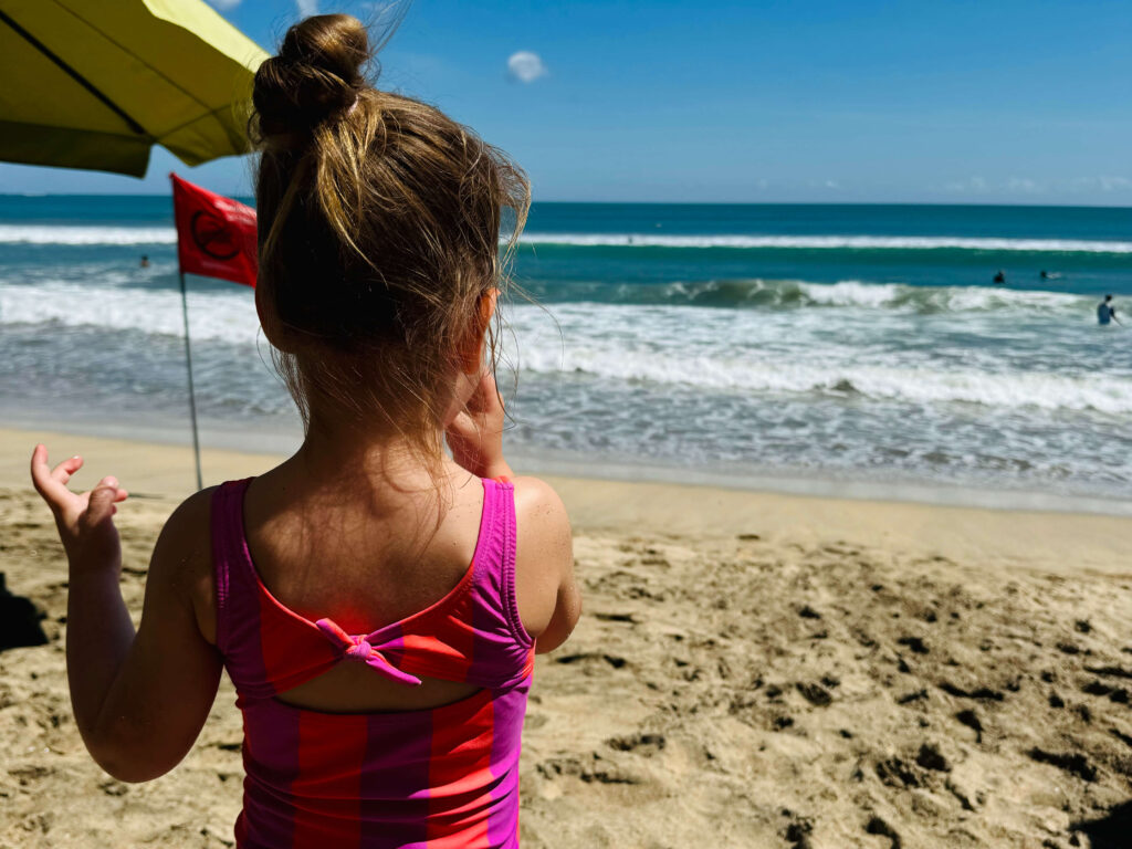 Peuter speelt op het strand in Kuta, Bali
