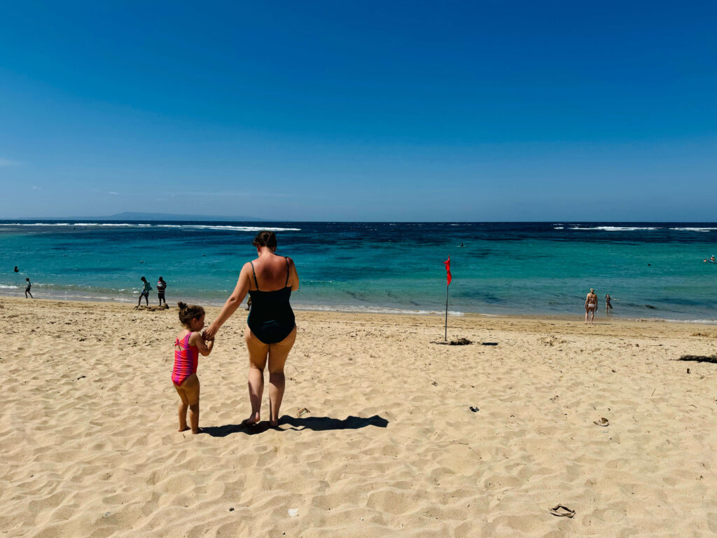 Family walking to sea at Mengiat beach in Bali