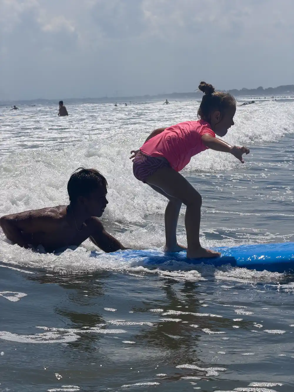 5-year-old daughter enjoying her first surf lesson on a beginner-friendly beach in Bali