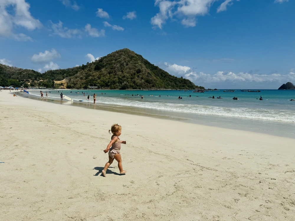 Peuter rent richting de zee op Selong Belanak strand in Lombok