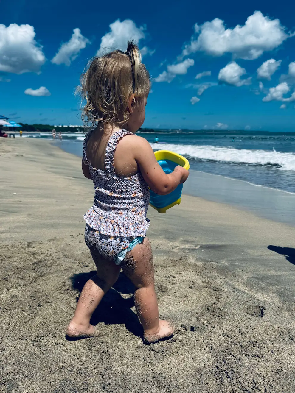 Toddler playing at kuta beach while being on a family holiday to Bali