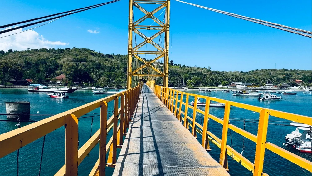 Oversteken yellow bridge met kinderen om naar nusa ceningan te komen vanaf nusa lembongan