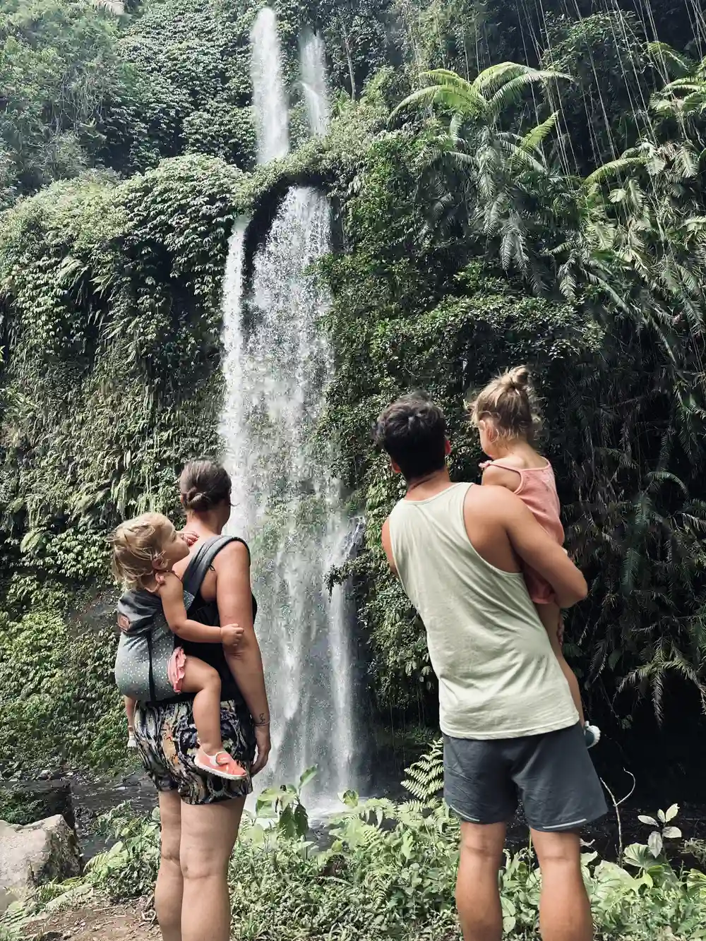 Peuter in draagzak tijdens wandeling naar watervallen