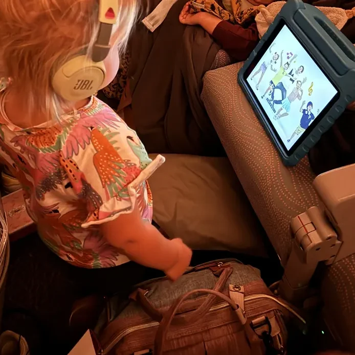 iPad met kinderkoptelefoon – onmisbaar voor lange vluchten naar Bali.