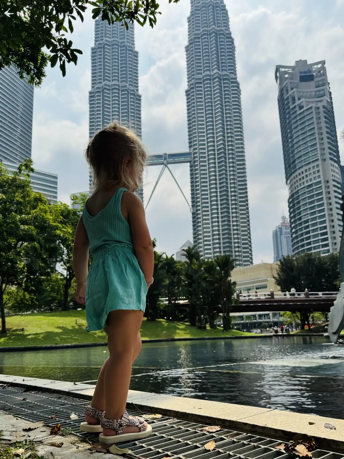 Kinderen genieten van KLCC Park en de Petronas torens in Kuala Lumopur