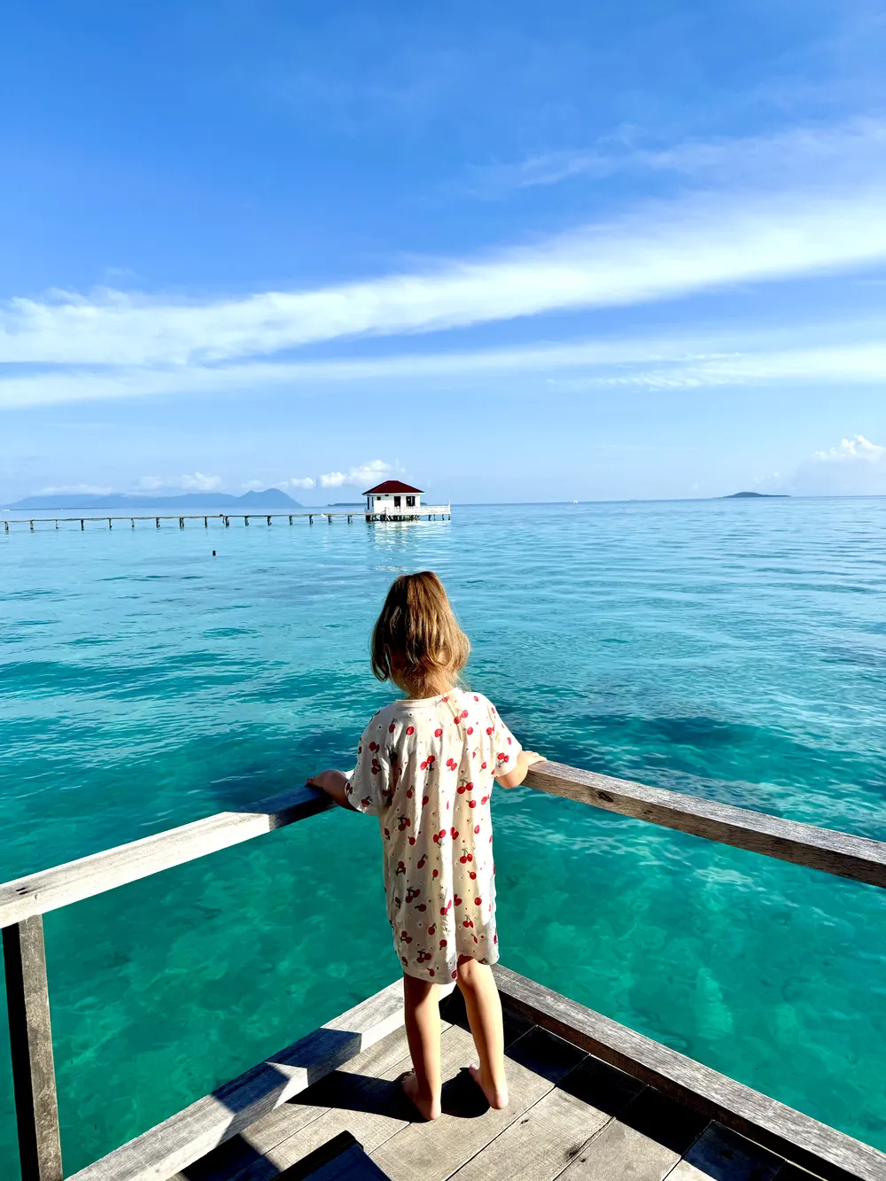Child waking up in an overwater bungalow near Semporna, Borneo