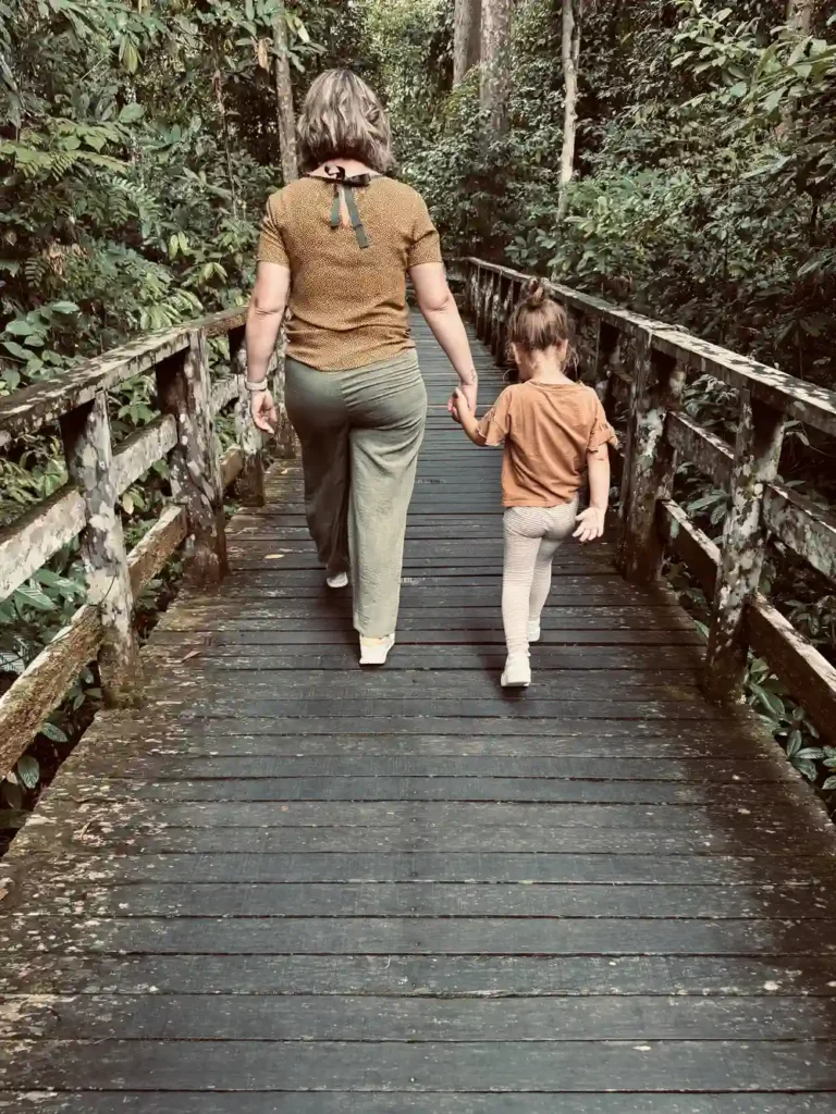 Kinderen lopen over een houten pad naar het voederplatform in Sepilok.