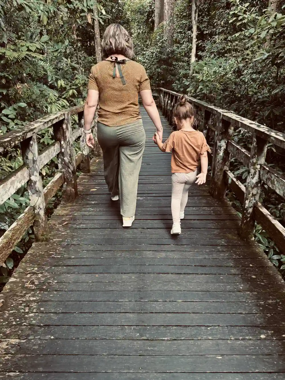 Mother and daughter walking on boardwalk at Sepilok