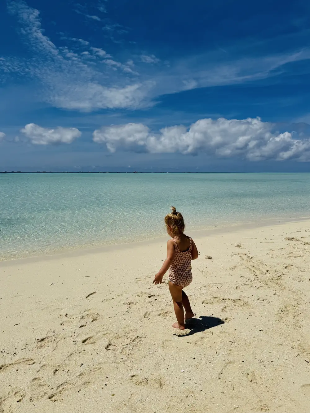 Peuter speelt op het strand van Timba Timba eiland