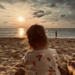 Girl watching the sunset on a beach in Phuket Thailand