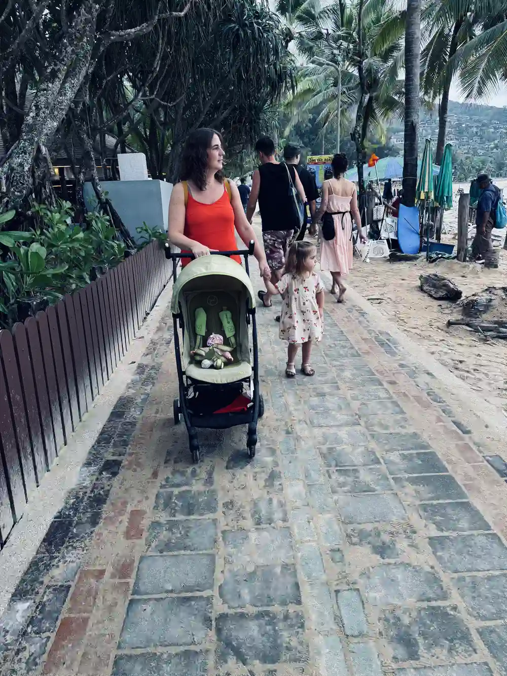 Family using a travel stroller while exploring Thailand with a toddler