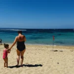Mother and daughter walking along Nusa Dua Beach, a family-friendly resort area in South Bali