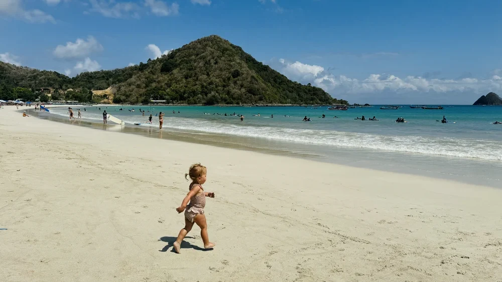 Toddler running to the ocean on Selong belanak beach in Lombok
