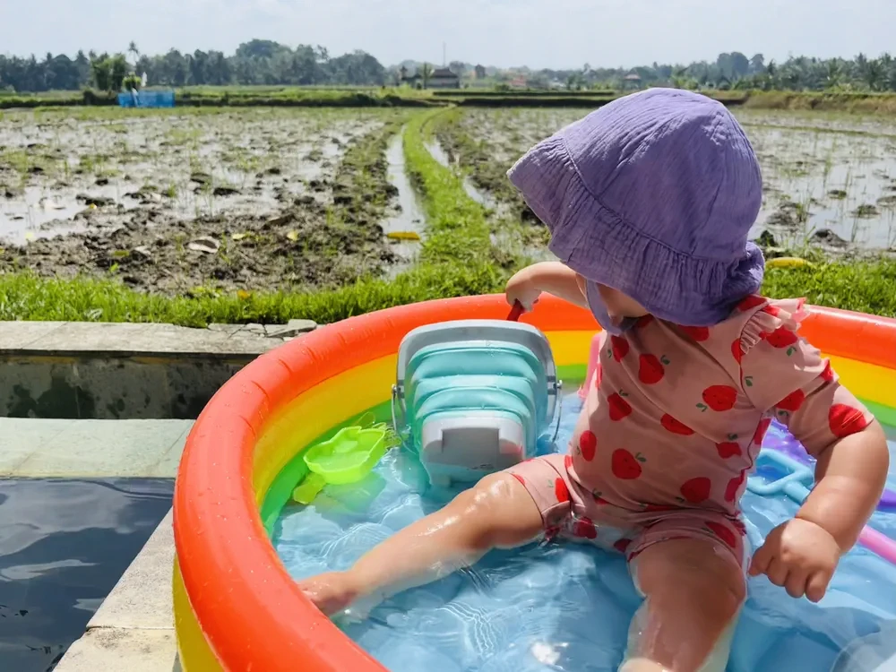 Mother carrying child at Sekumpul waterfall Bali