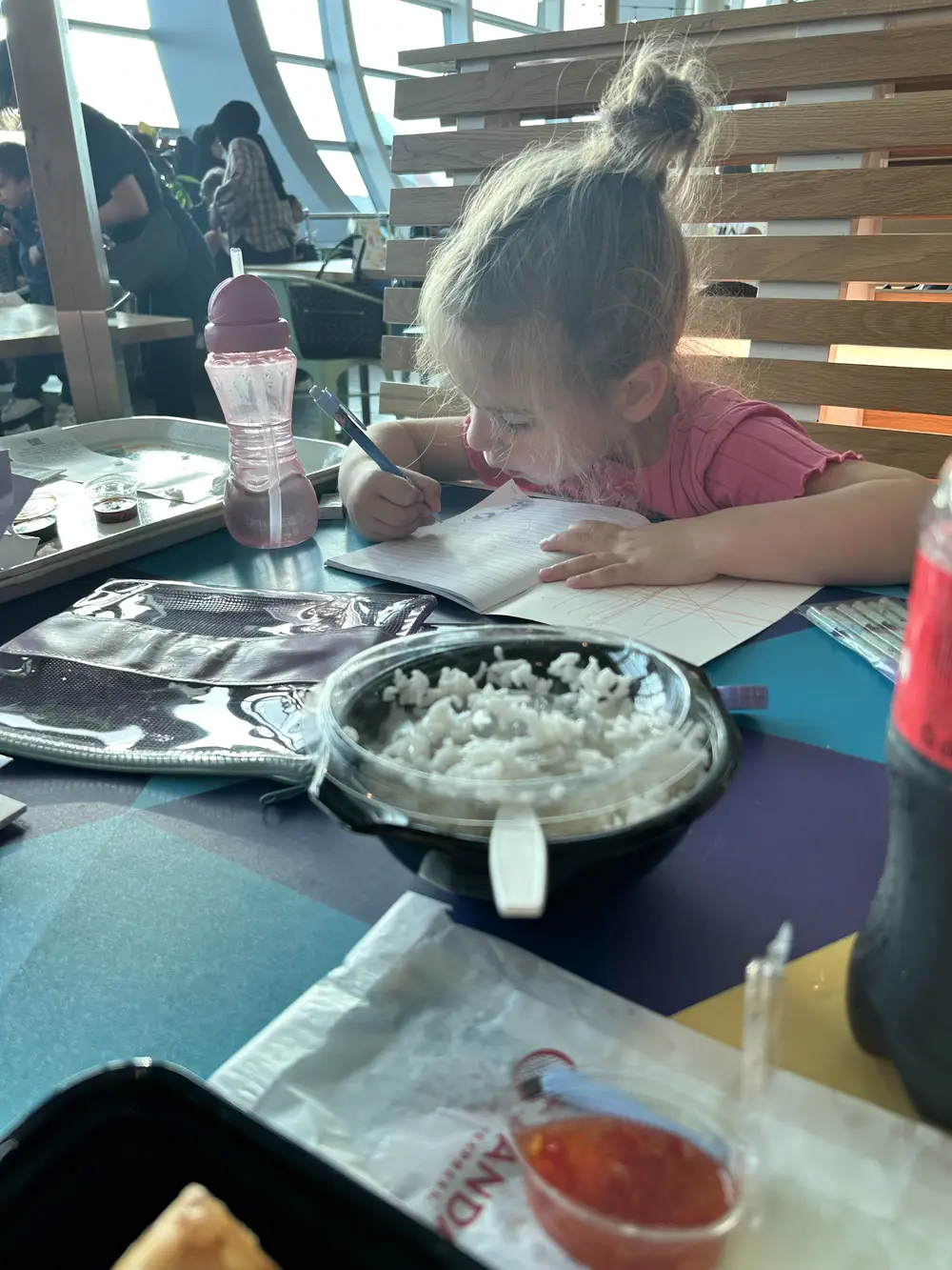 Airport activities for kids, daughter drawing in travel journal