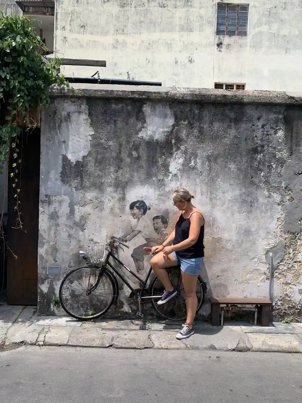 woman exploring street art in George Town Penang during a Malaysia itinerary with kids