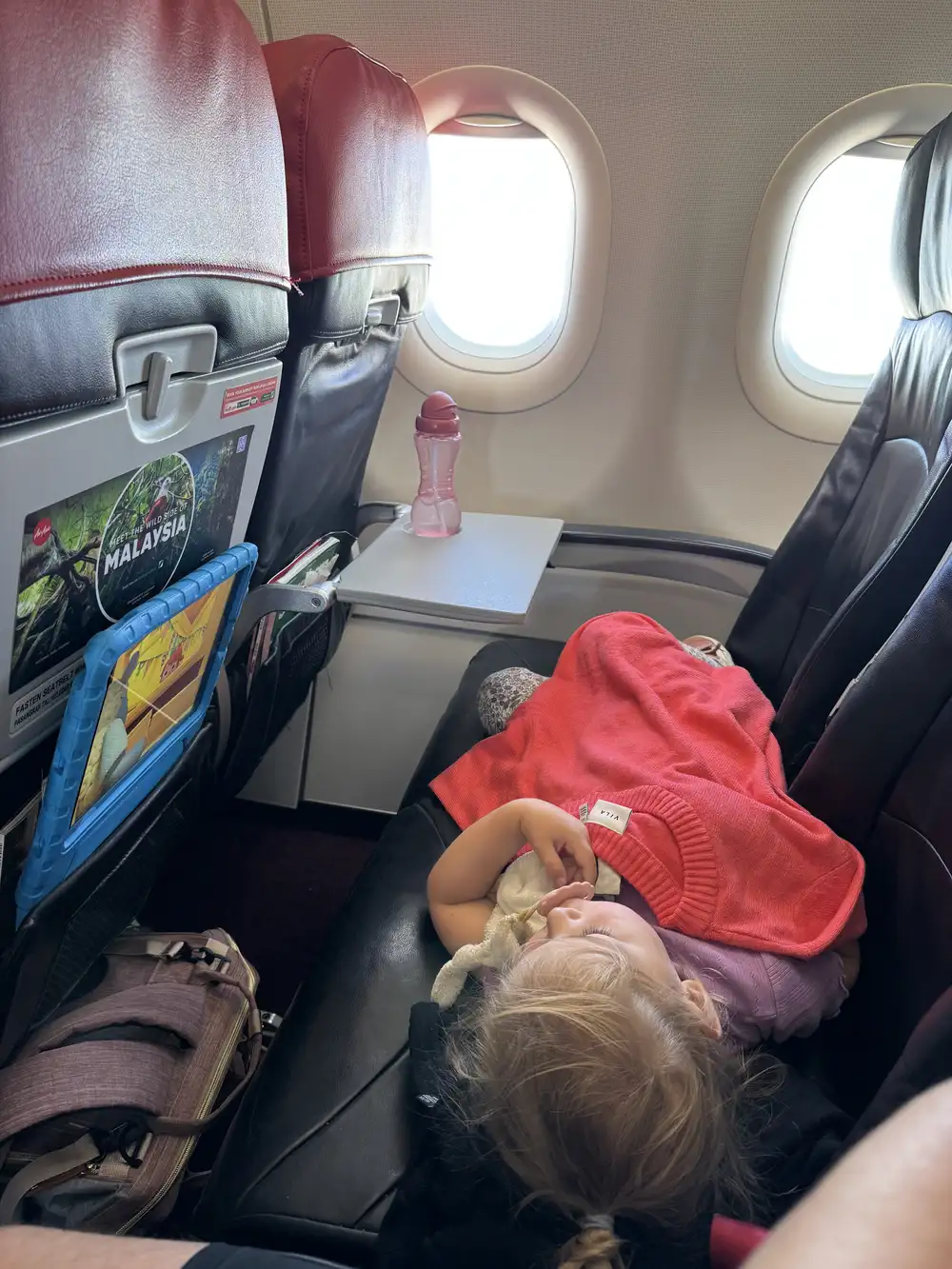 Children watching downloaded movie on tablet during airplane flight