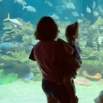 Mother and daughter watching fish at Aquaria KLCC in Kuala Lumpur