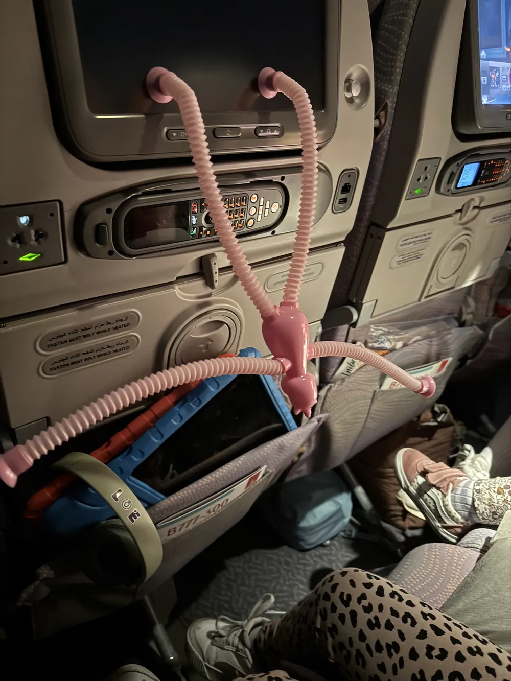 Toddler playing with small toys on airplane tray table during flight