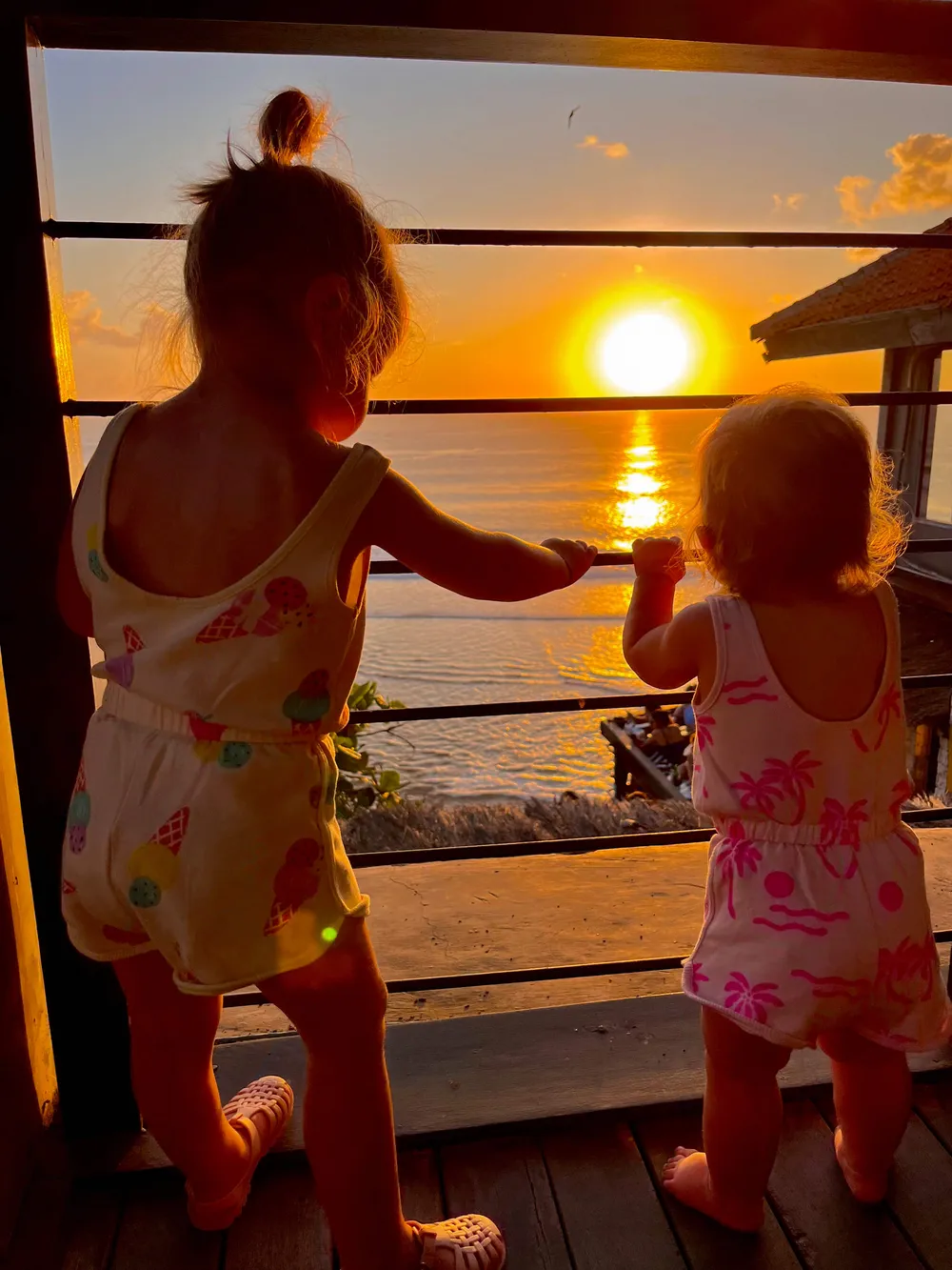 Children watching sunset from the cliffs in Uluwatu, Bali