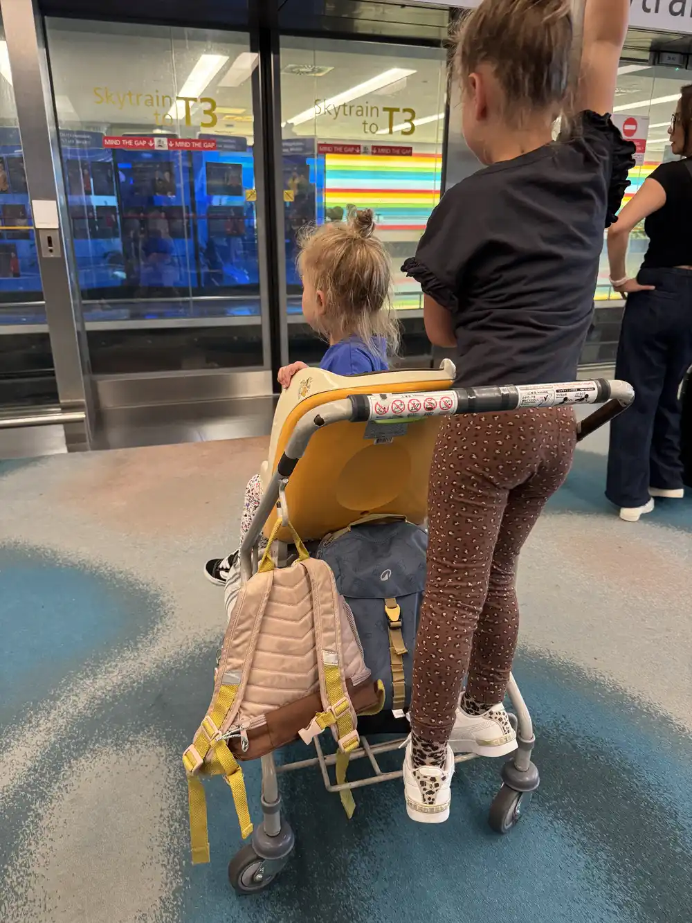 Sisters using a free airport stroller at Changi Airport