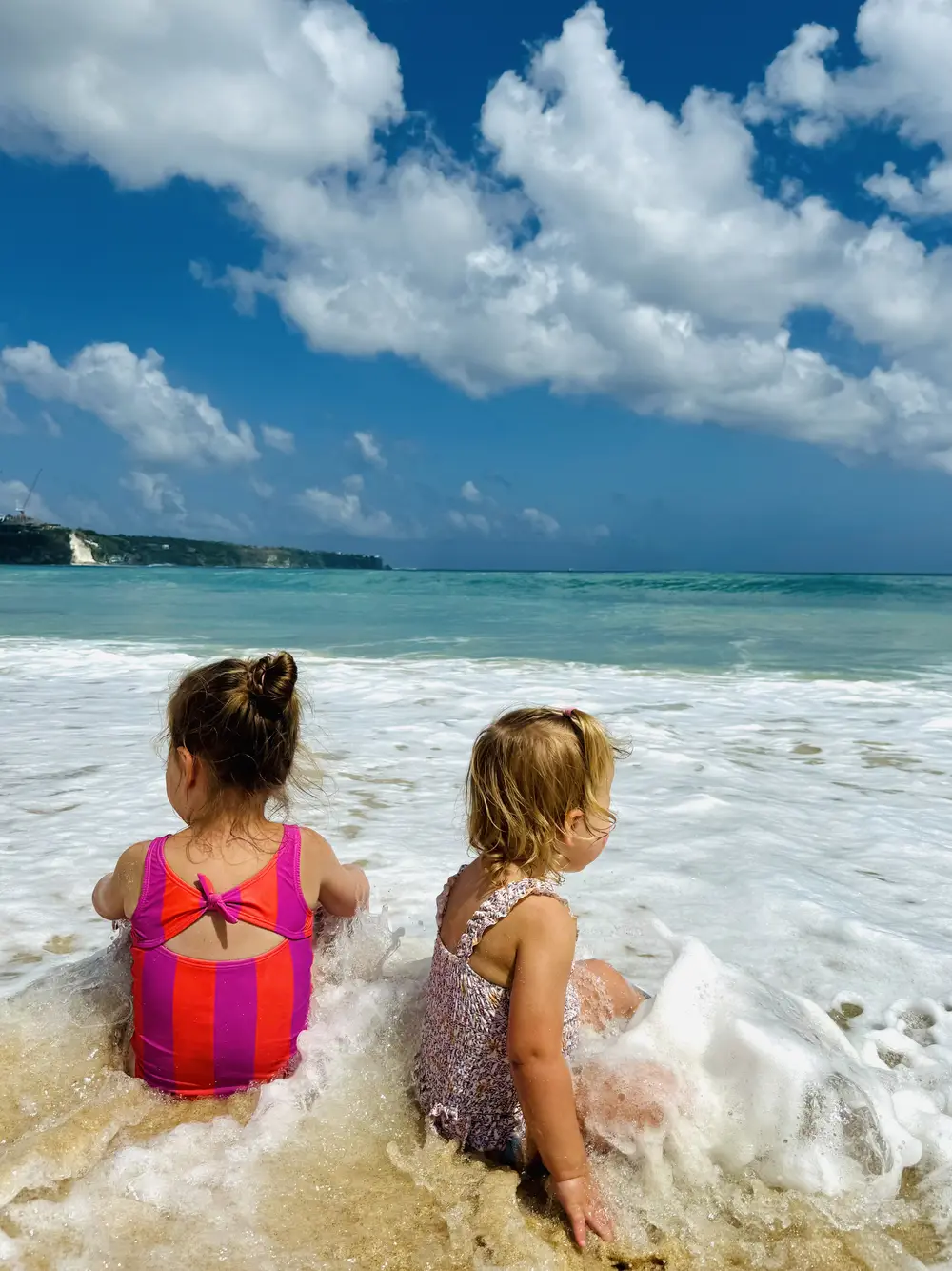 Kids playing in the waves at Dreamland Beach in Uluwatu, Bali