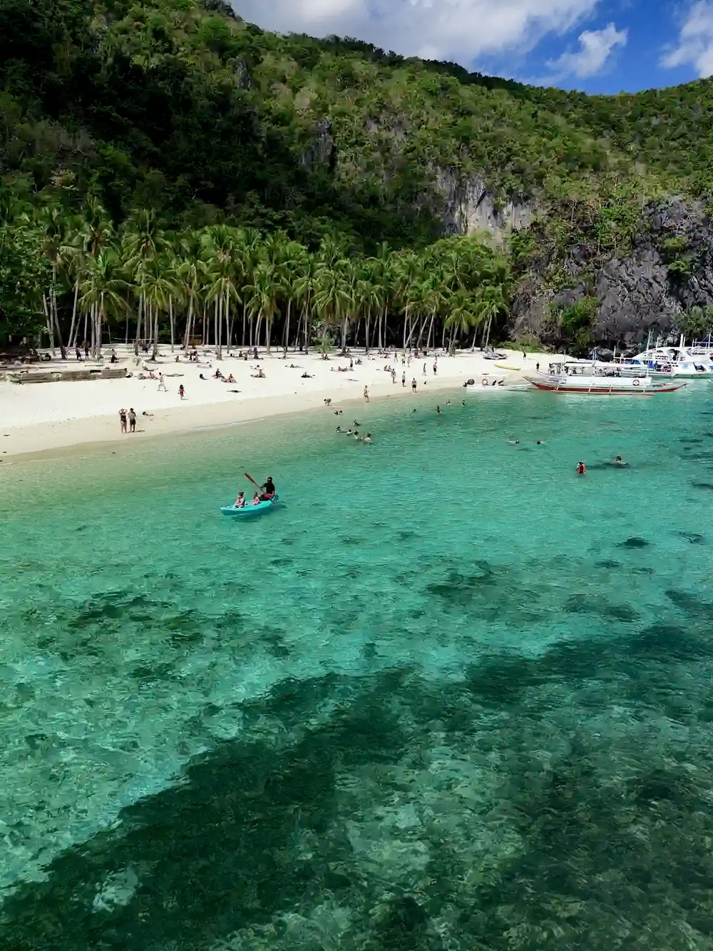 Children kayaking near Helicopter Island during an island-hopping tour in El Nido, Palawan