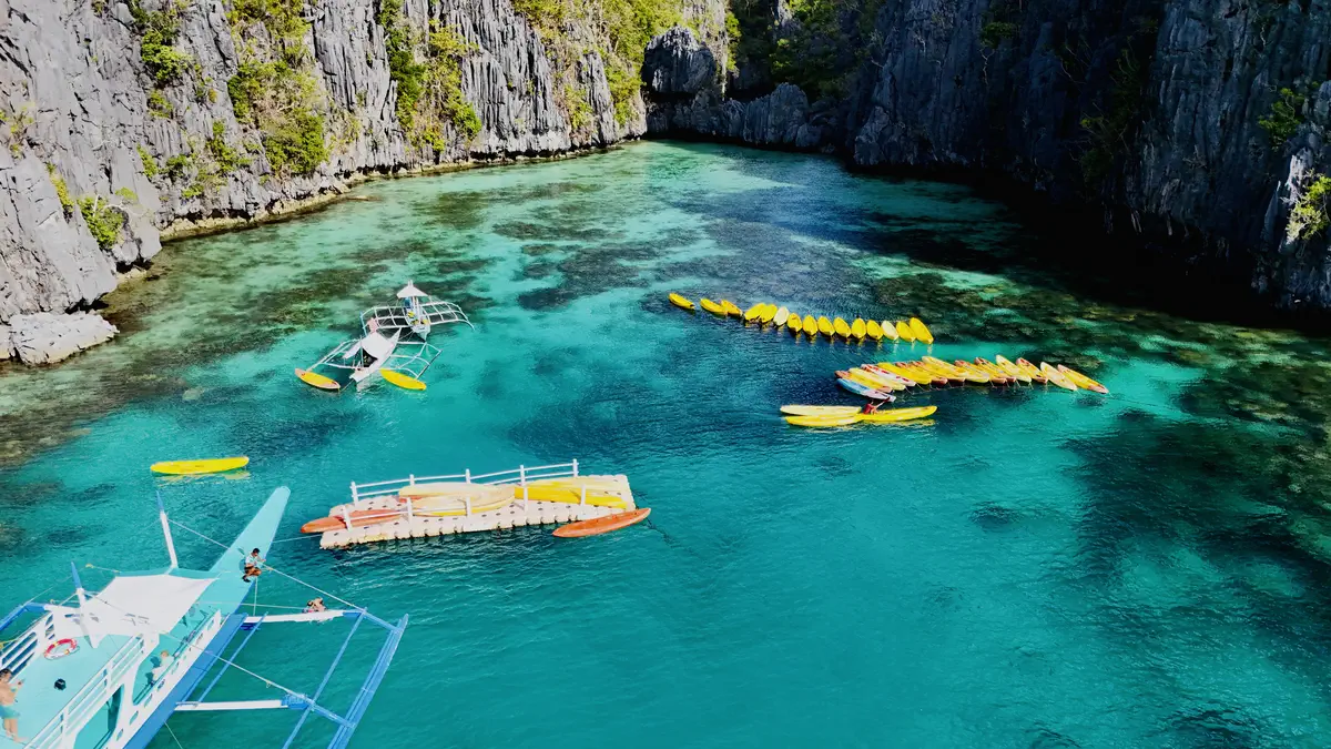 Children playing near a boat in Small Lagoon, El Nido, Palawan during a family trip to the Philippines