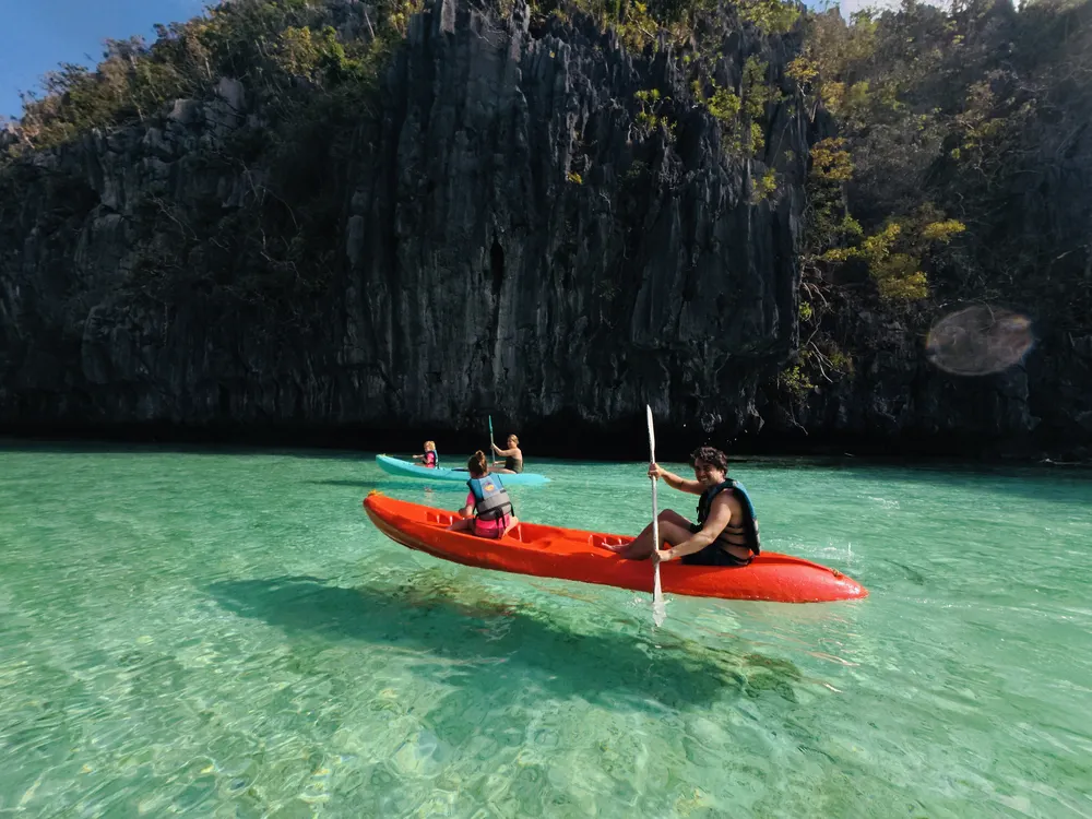 Family kayaking through Big Lagoon in El Nido, Palawan with kids