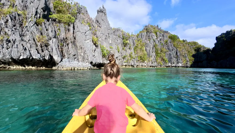 Girl kayaking in Small Lagoon, El Nido, Philippines