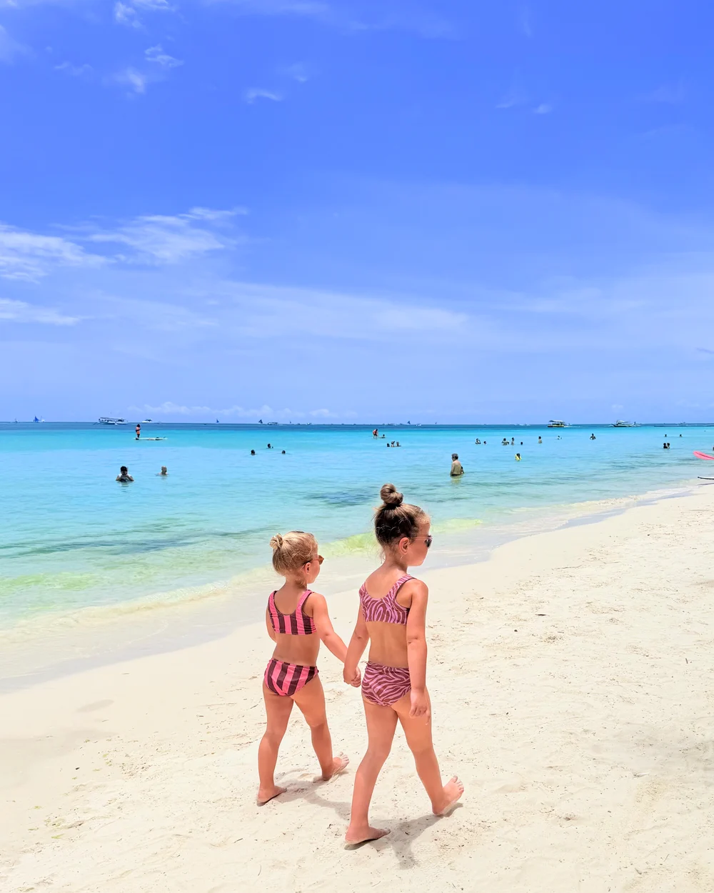 Daughters walking along White Beach in Boracay during a family vacation